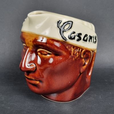 une tête d'homme en céramique coiffée d'un chapeau