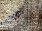 a rug on the floor with a chair in the background