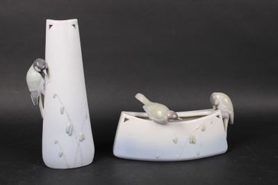 two white vases with birds on them sitting next to each other