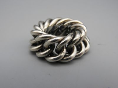 gros plan d'une bague en argent sur une surface blanche