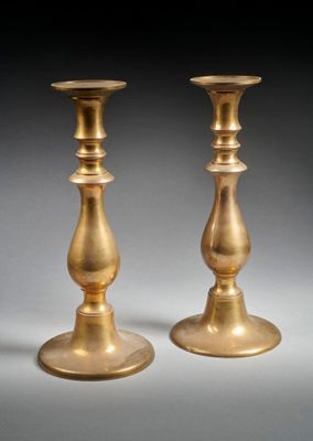 paire de chandeliers anciens en laiton sur fond gris