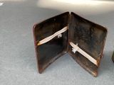 a small wallet sitting on a table next to a bottle
