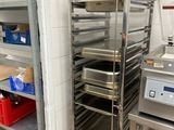 a metal rack with trays of food in a kitchen