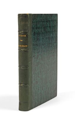 un vieux livre à la couverture verte posé sur une surface blanche