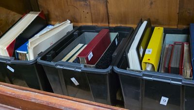 beaucoup de livres dans les bacs posés sur l'étagère