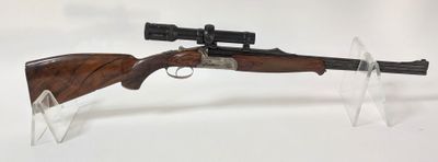 le fusil est posé sur un support transparent posé sur la table