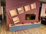 a picture of a living room with a flat screen tv on the wall