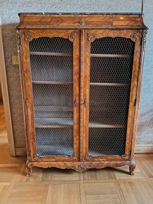 une armoire en bois avec une porte vitrée, posée au sol