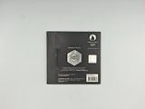 the back of a black and white photo of a medal on a white surface