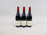 trois bouteilles de vin posées sur une table blanche