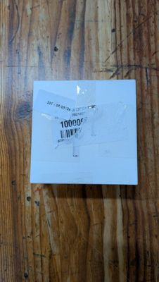 a piece of paper on a wooden table that has a sticker on it
