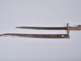 a pair of old and worn swords on a white surface