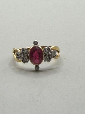 a close up of a gold ring with a ruby stone