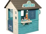 un petit bâtiment bleu et blanc au toit marron