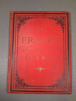 un livre rouge posé sur une table près d'un mur