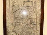 an old map hangs on a wall in a room