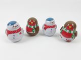 three small wooden snowmen sitting next to each other on a white surface