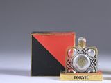 a small bottle of perfume sitting next to a box