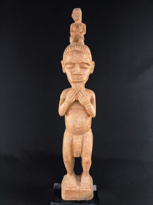 a carved statue of a man with a bird on his head
