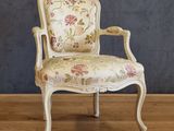 a white chair with a floral upholstered on it