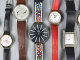 many different types of watches displayed on a table