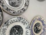 a lot of plates on the wall with pictures on them