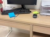 a desk with a computer, keyboard, mouse, and other items on it