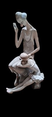 une statue représentant une femme assise sur les genoux d'un homme