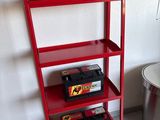 a red shelf that has a bunch of items on it