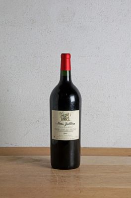 a bottle of red wine sitting on a wooden table