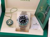 a rolex watch in a green box with a chain