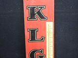 une vieille enseigne rouge et noire sur laquelle est inscrit « klg »