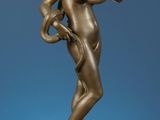 une statue antique en bronze représentant un homme tenant une balle, posée sur un socle en marbre