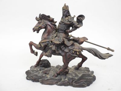 une statue représentant un homme à cheval sur un rocher