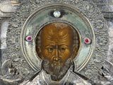 an image of a metal plaque with a picture of a man with a beard and a cross on it