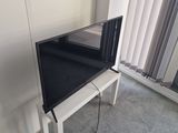 un téléviseur à écran plat posé sur un support dans le coin d'une pièce