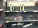 many empty shelves in the store with empty bottles