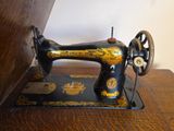a black and gold sewing machine sitting on a wooden table