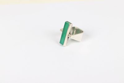 a close up of a ring with a green stone on it