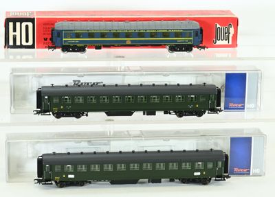 trois wagons de train miniature sont exposés dans une vitrine posée sur une surface blanche