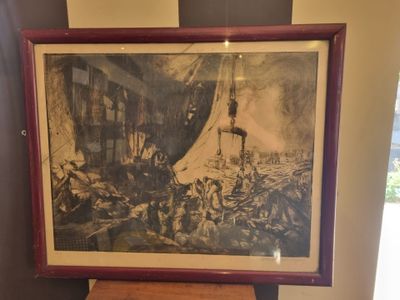 framed picture of a painting of a man on a boat in a room