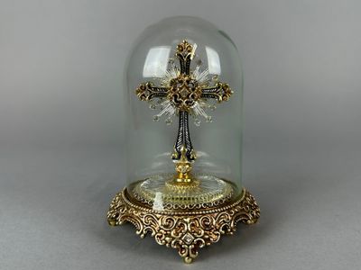 un dôme en verre renfermant une croix en or