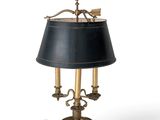 an antique brass table lamp with a black shade on a white background