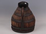 a wooden barrel with a metal handle on a table