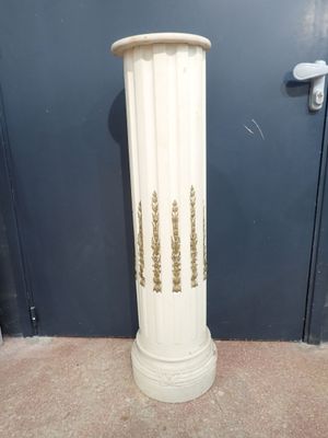un grand vase blanc posé par terre devant une porte