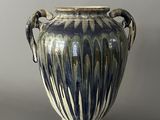 a blue and white vase with handles on a gray background