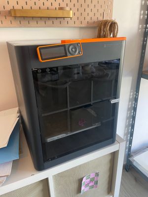 un four noir et orange posé sur une étagère dans une pièce