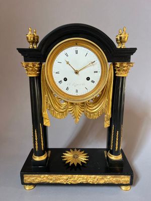 a black and gold clock with a gold star on it