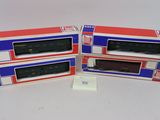 trois boîtes contenant des trains miniatures posées sur une surface blanche