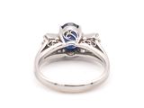 a close up of a diamond and sapphire ring on a white background